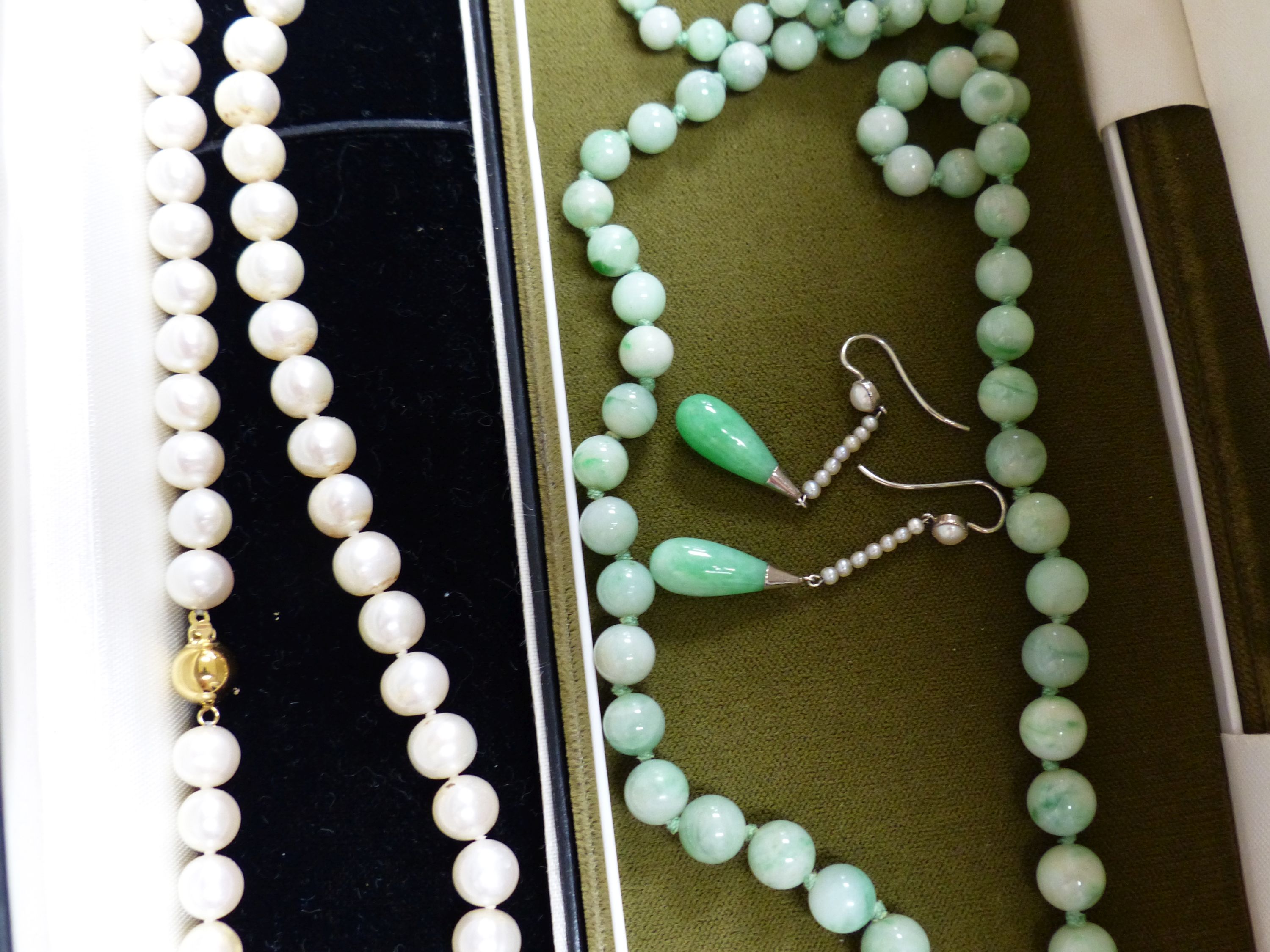 A single row uniform cultured pearl necklace with 9ct gold ball clasp, a graduated jade bead necklace and a pair of jade and seed pearl drop earrings, 37mm